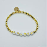bracelet made of gold beads with white beads with gold letters