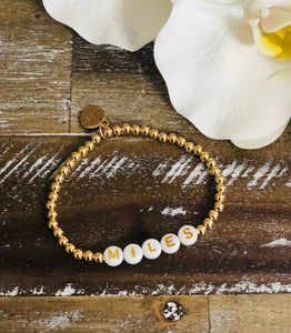bracelet made of gold beads with white beads with gold letters